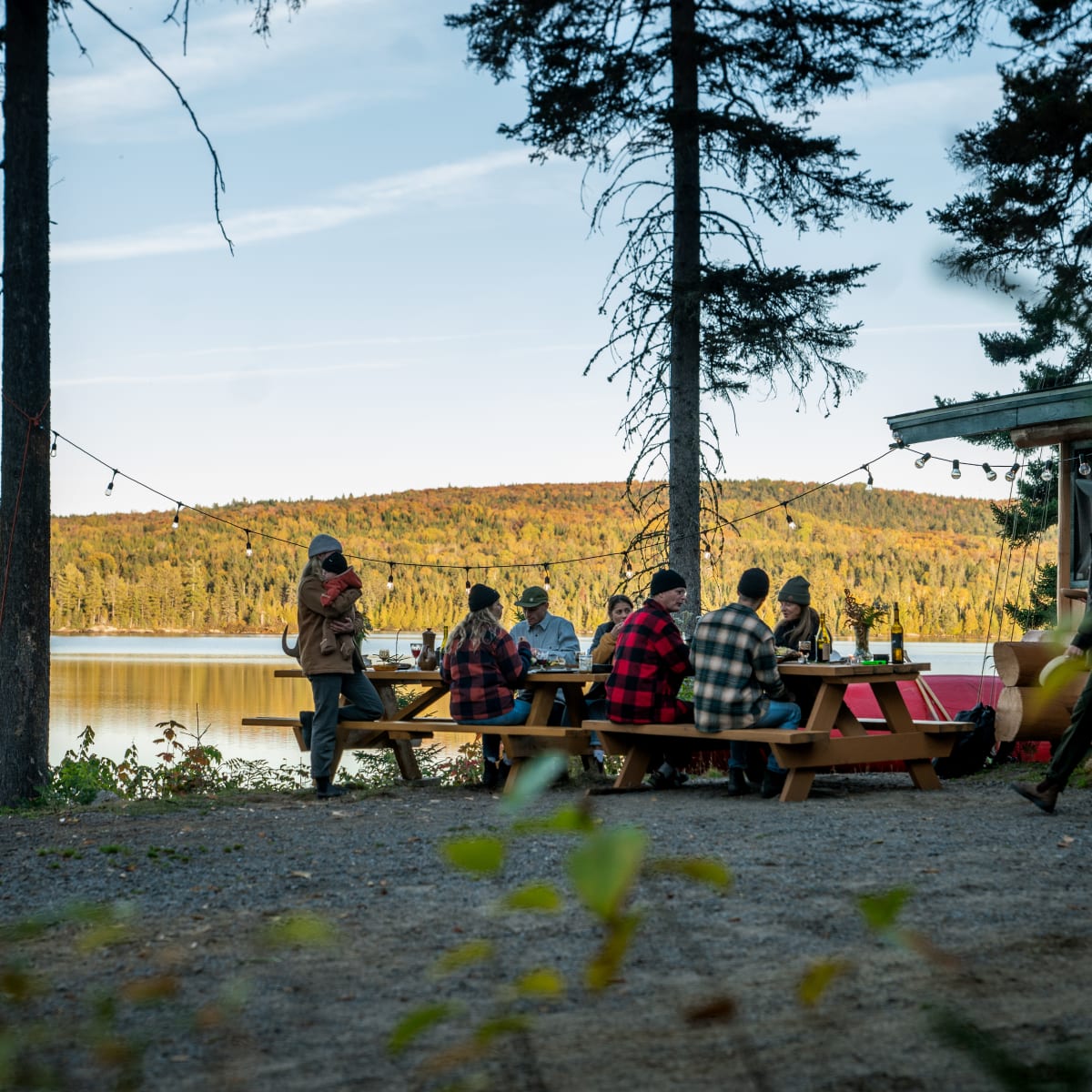 A group of friends at a picnic table by the water