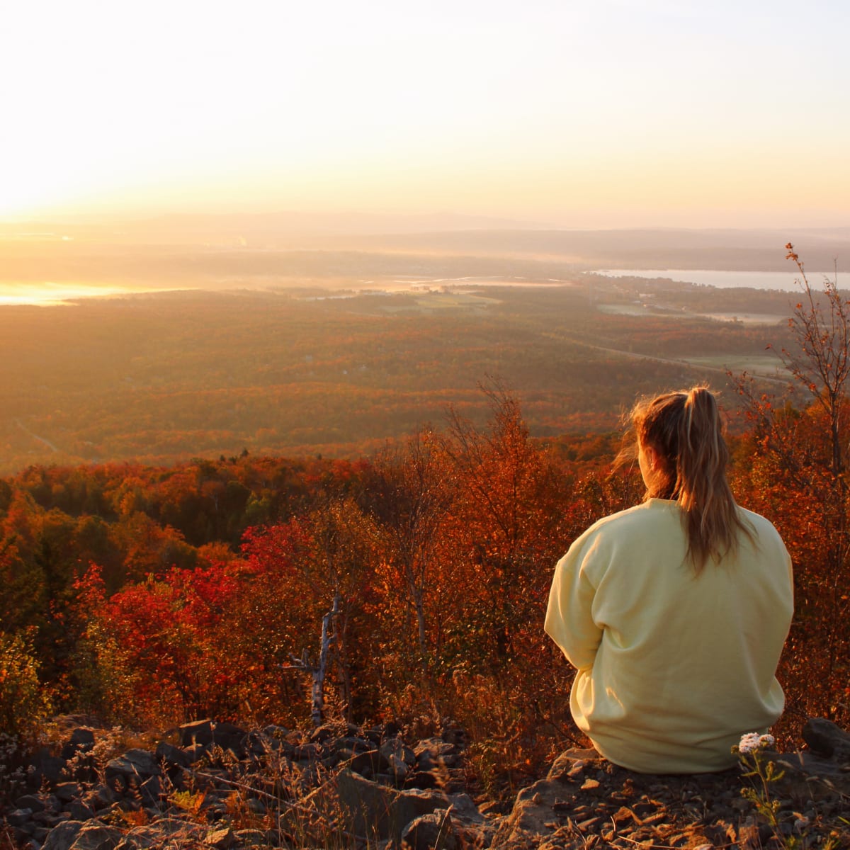 Discover the magic of autumn in Memphremagog - Hiker at the summit of Mont Orford in the fall