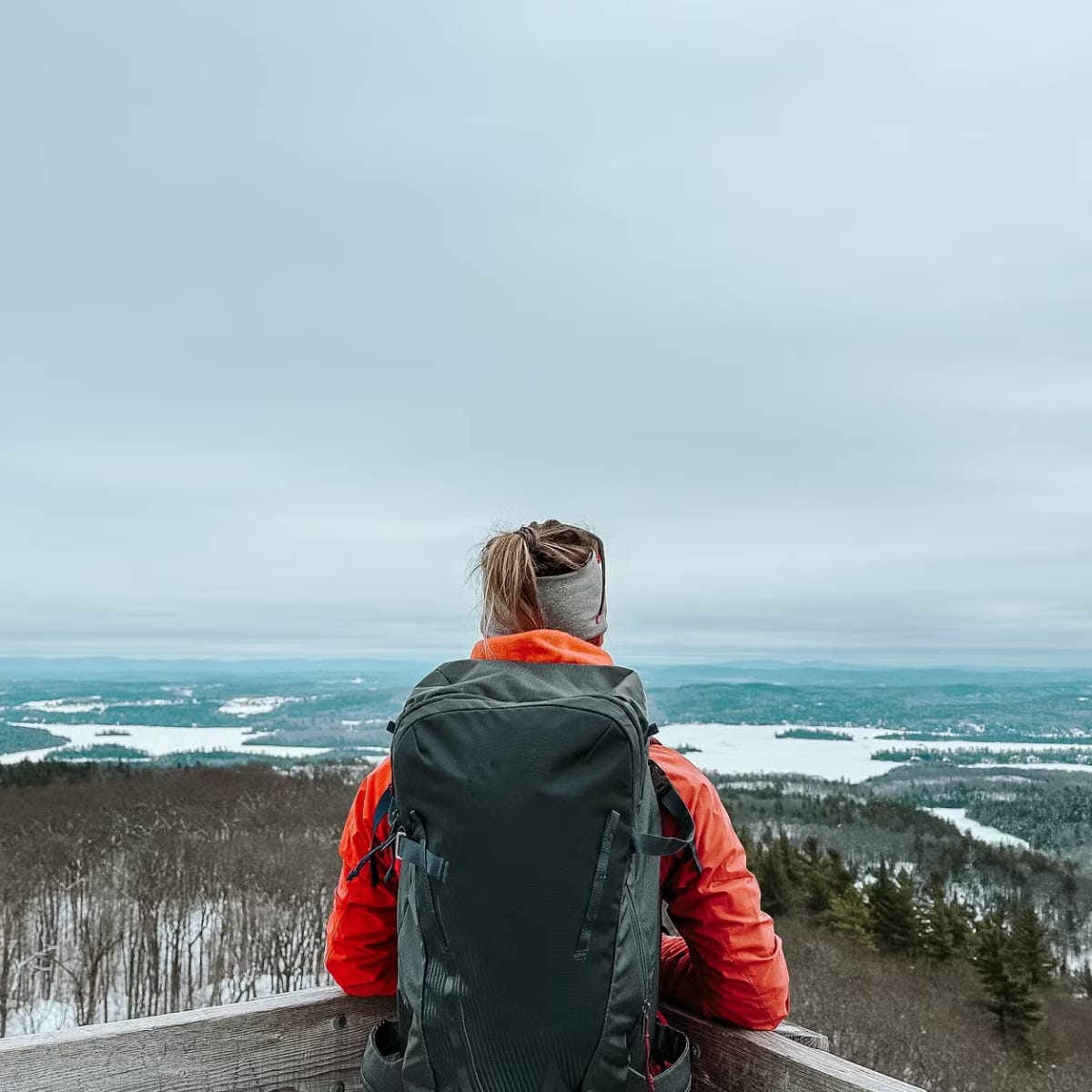 Découvrez l’Outaouais et ses territoires grâce à ces incontournables! - Randonneuse admirant la vue d'un sommet en hiver