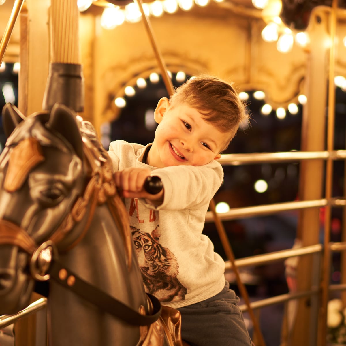 Boy on a merry-go-round at Méga Parc.
