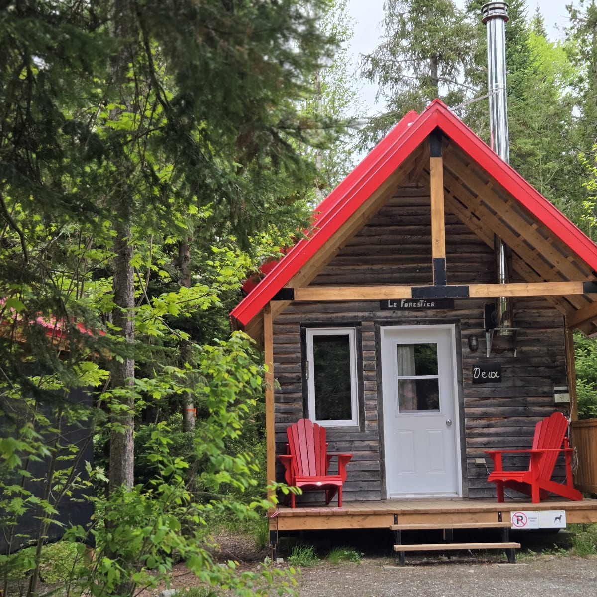 Micro-Chalets des Appalaches - Petit chalet avec deux chaises rouges sur le balcon