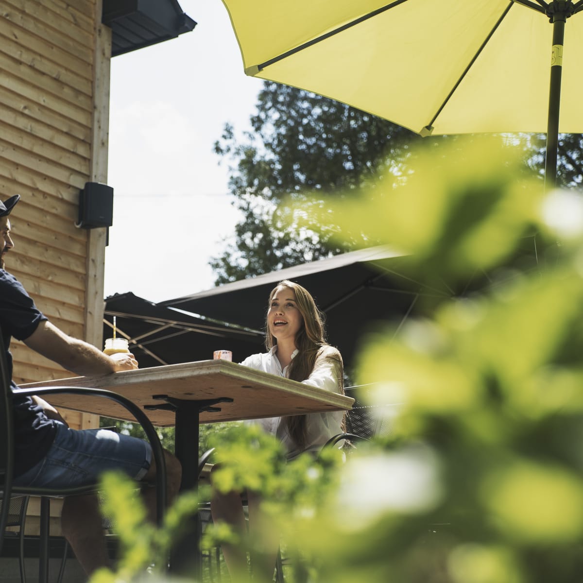 Municipalité d'Orford - Un couple assis à une table sur une terrasse extérieure