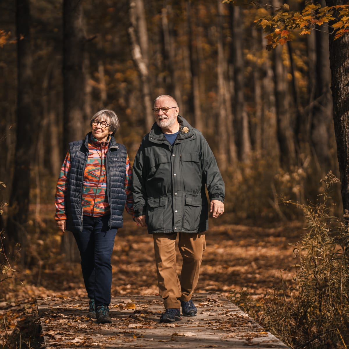 Municipalité d'Orford - Un couple marchant sur un sentier dans une forêt automnales