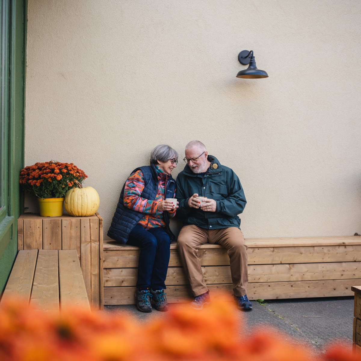 Municipalité d'Orford - Un couple assis sur une banquette de bois à l'extérieur, en automne