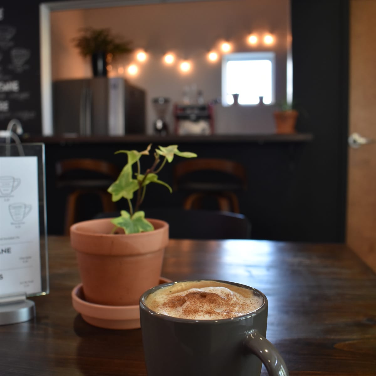 MA, Rouyn-Noranda Art Museum - A coffee and a plant on a wooden table