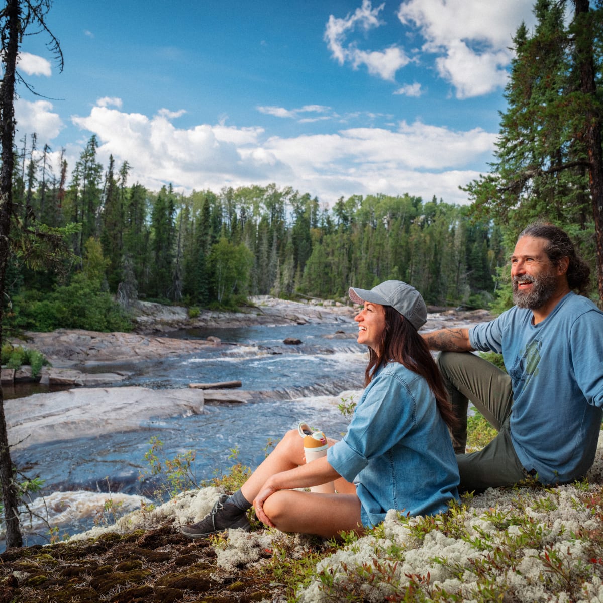 Homme et femme assis sur le bord de la rivière en été. 