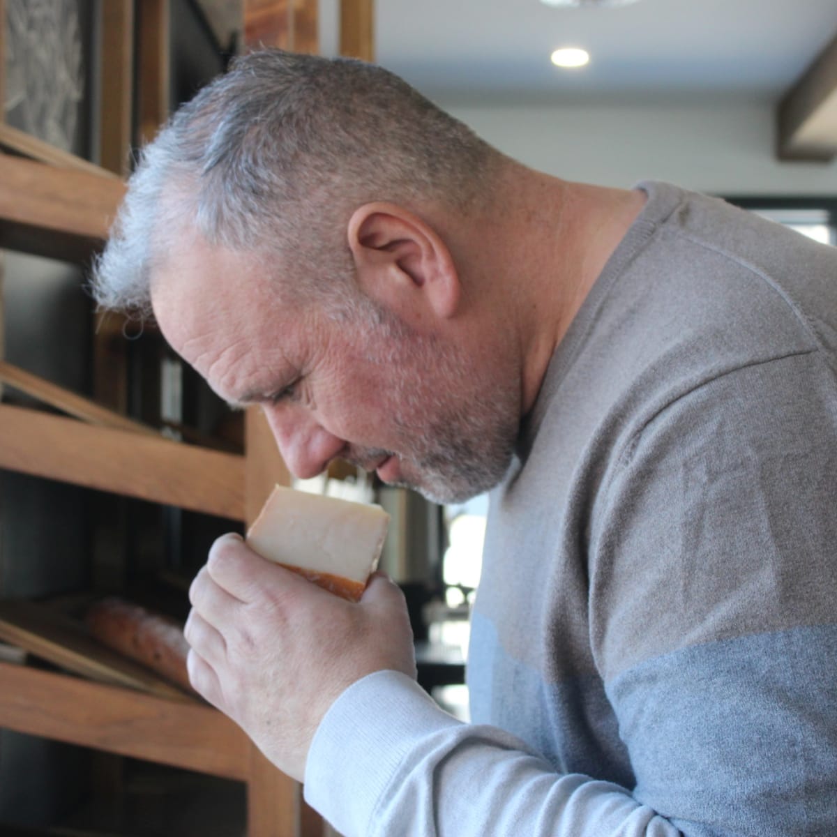 Un homme sentant un fromage.