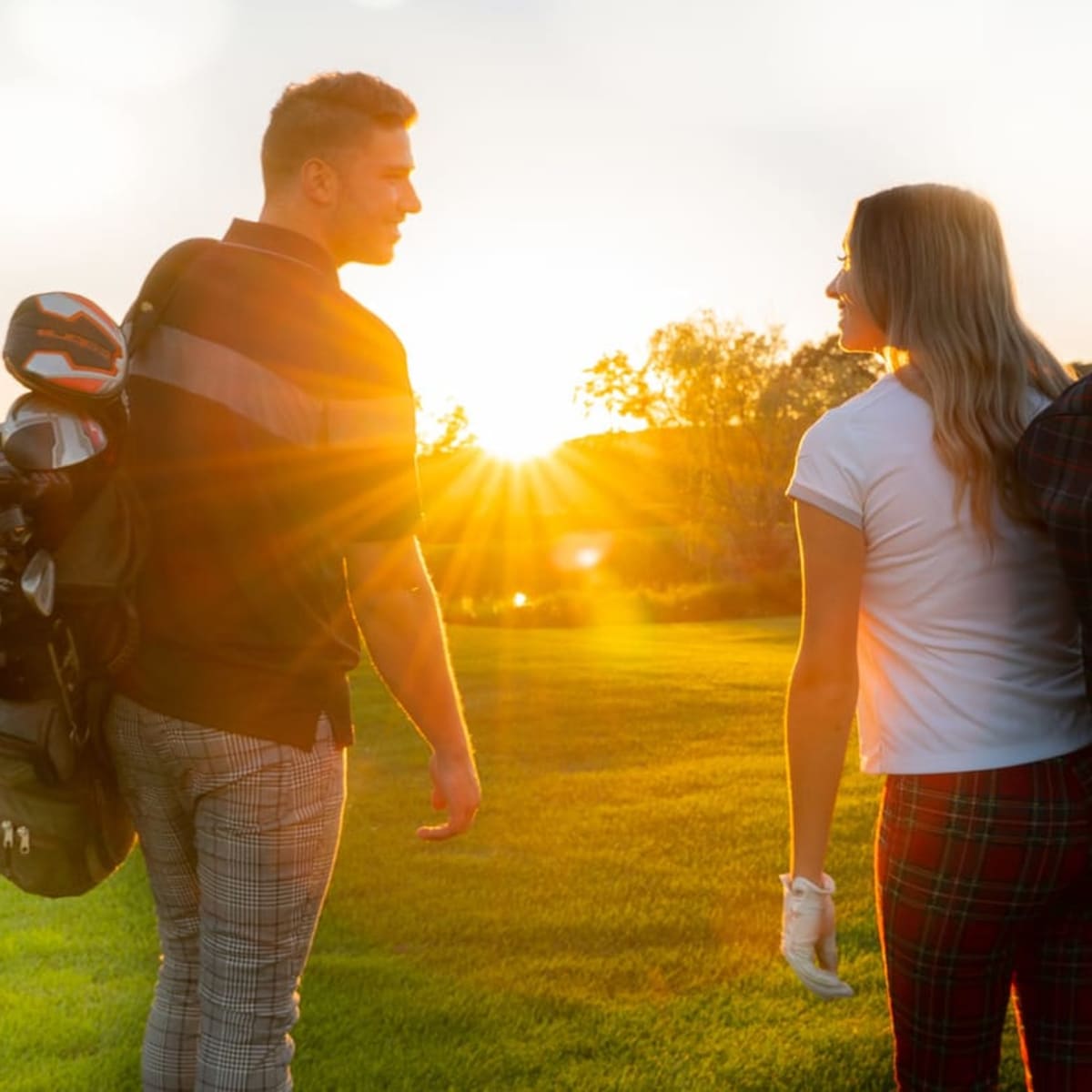 Couple de golfeurs au coucher du soleil.