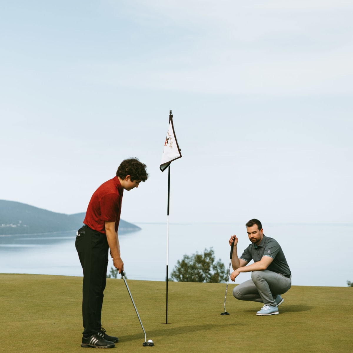 Père et fils en train de golfer au Golf Fairmont Le Manoir Richelieu.