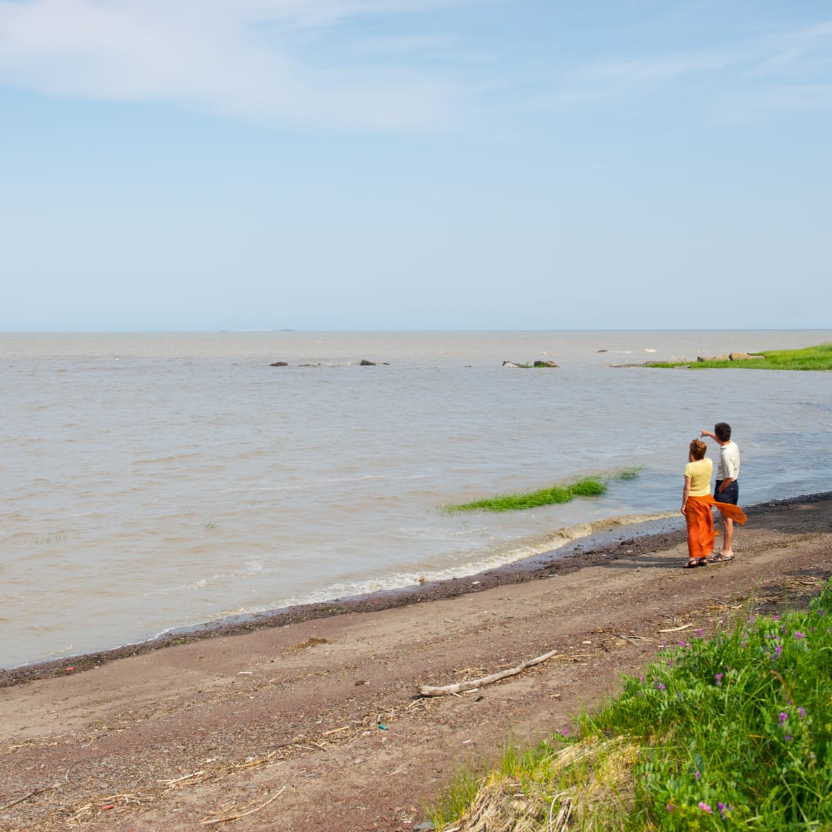 Couple au bord de l'eau qui regarde la rivière.