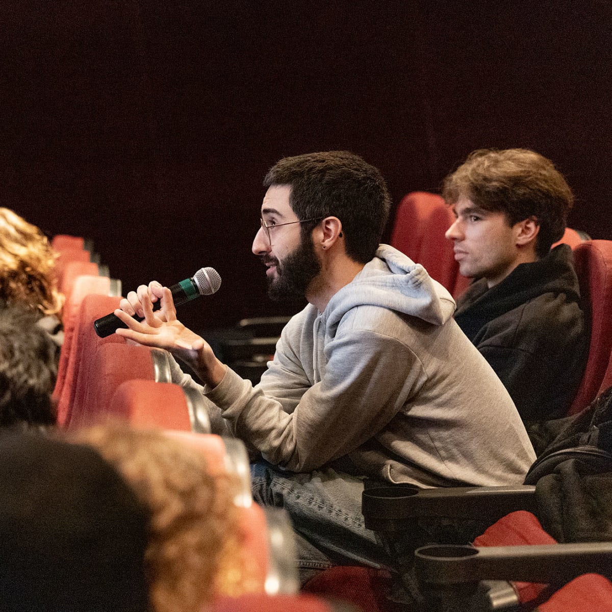 Un individu tient un microphone à l'événement Rencontres Internationales du documentaire de Montréal (RIDM).