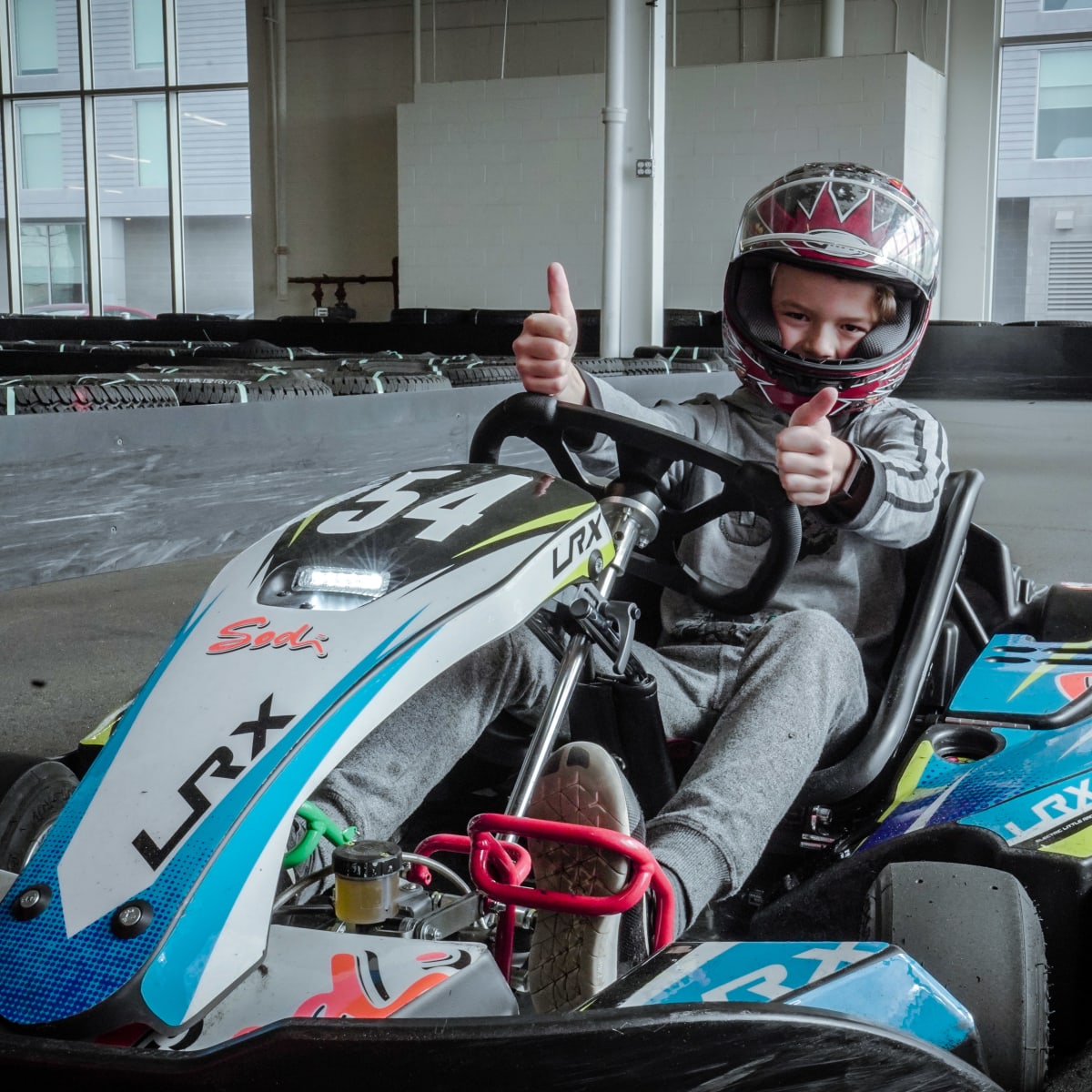 Jeune garçon dans un kart sur une piste de karting.