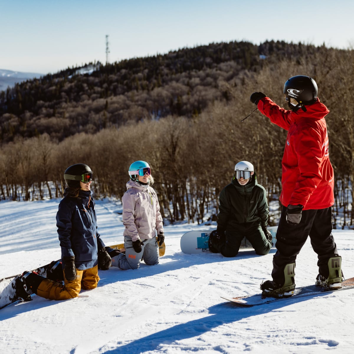 A group of people watching their ski instructor.