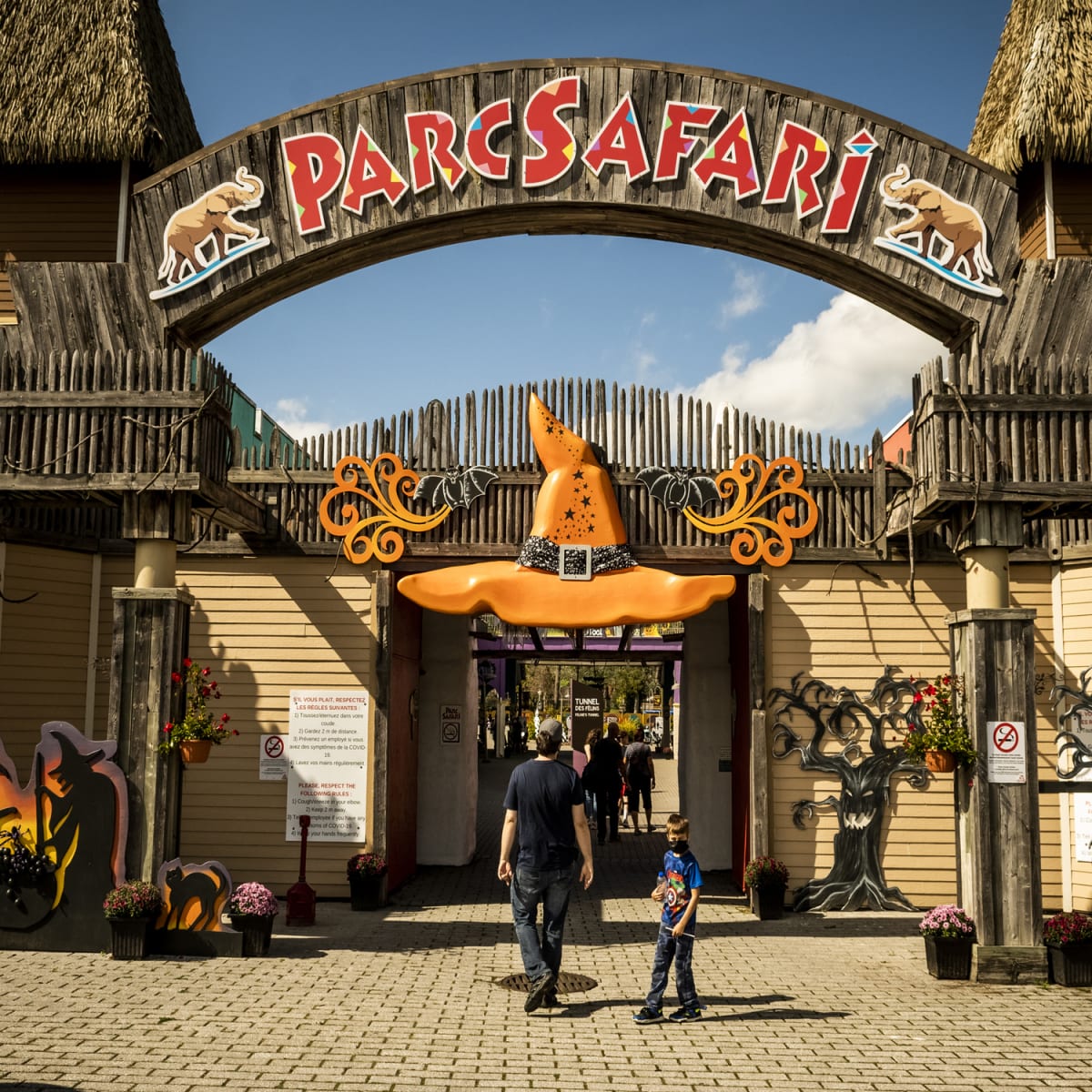 Père et fils à l'entrée du Parc Safari décorée pour l'Halloween.