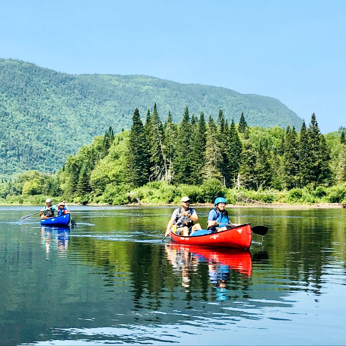 Two couples in two canoes on the lake.