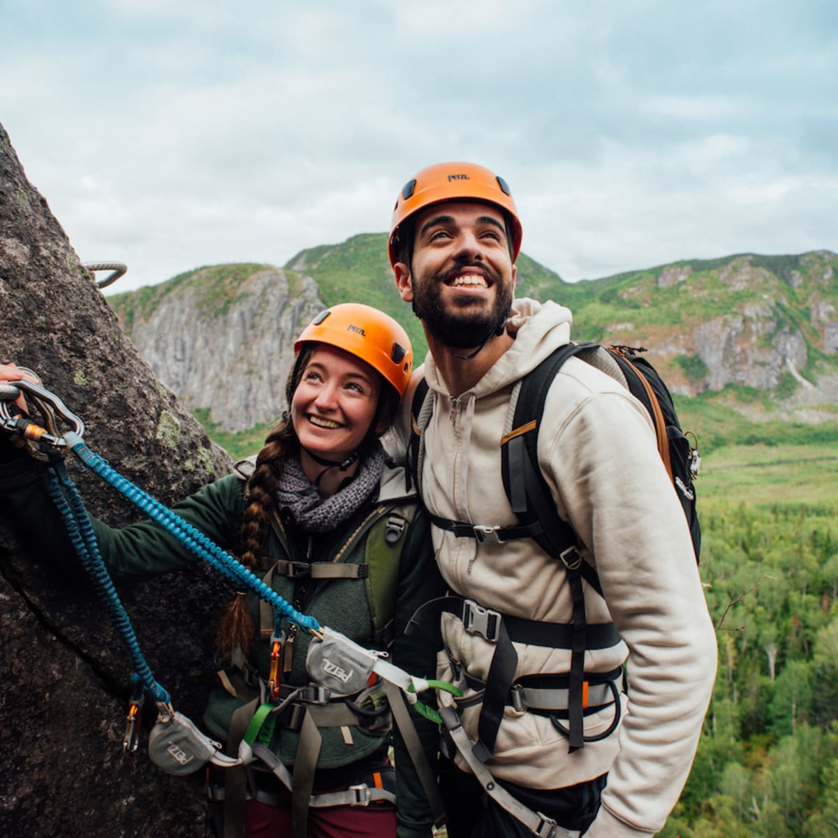 Happy couple on a cliff on a via ferrata trail.