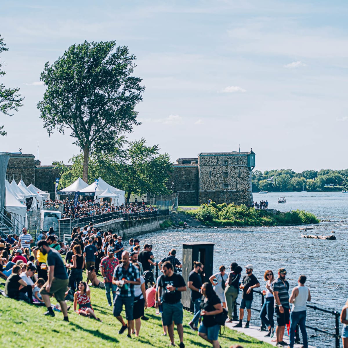 Foule assemblée au bord de l'eau lors d'un festival.