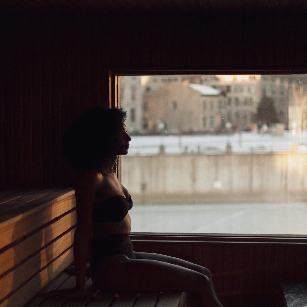 Woman in the sauna looking out over the Old Port of Montreal.
