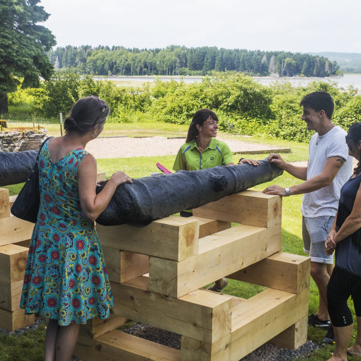 Guide and 3 visitors around a cannon at Bourg de Pabos.