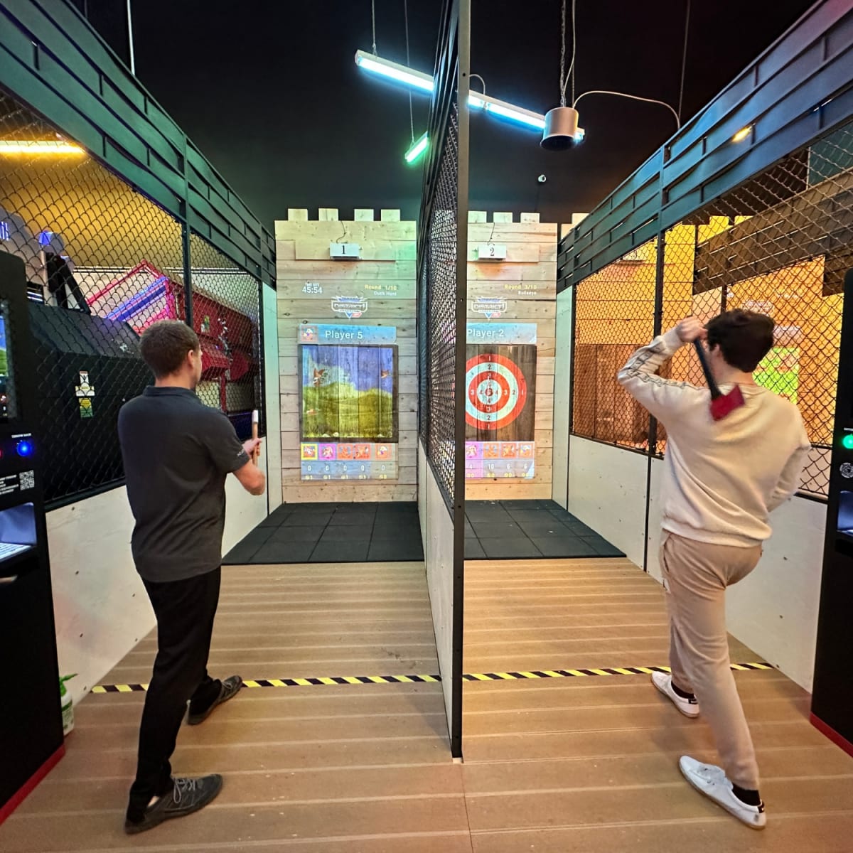Two men taking part in an axe-throwing activity.