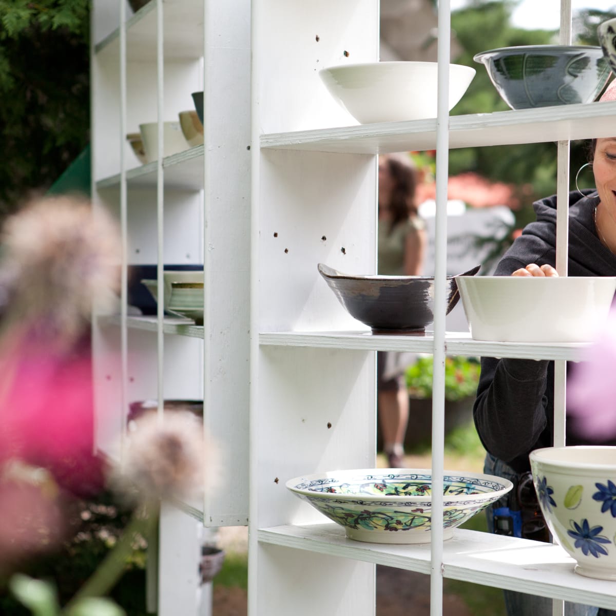 Smiling woman looking at ceramic bowls.