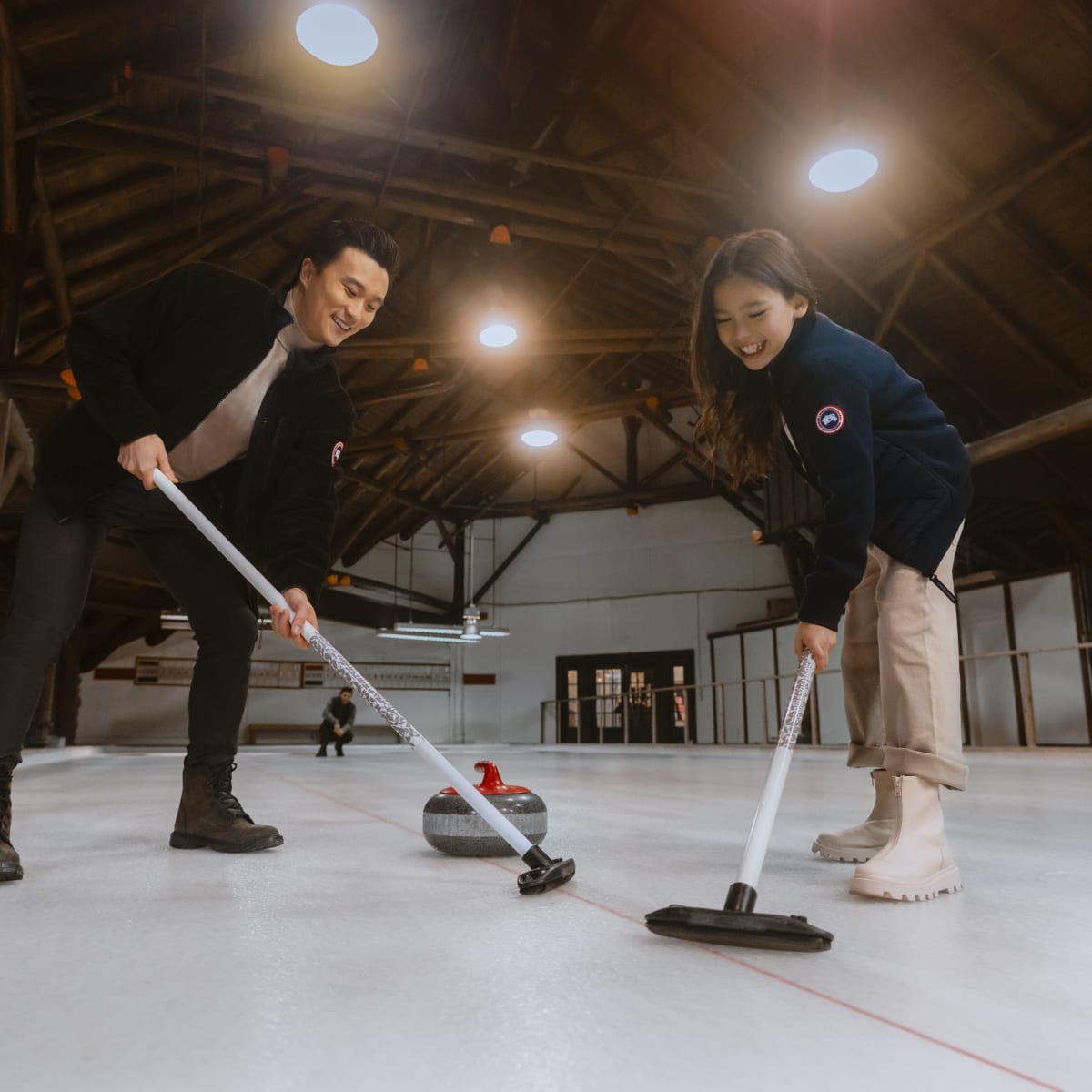 Deux personnes en train de jouer au curling.