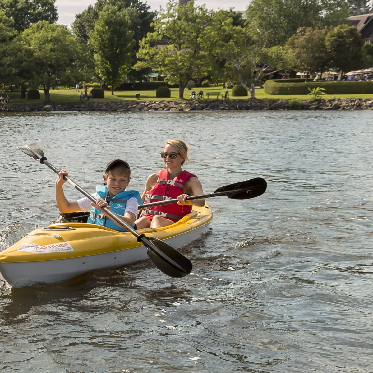 Mother and son in a canoe in front of Château Montebello.