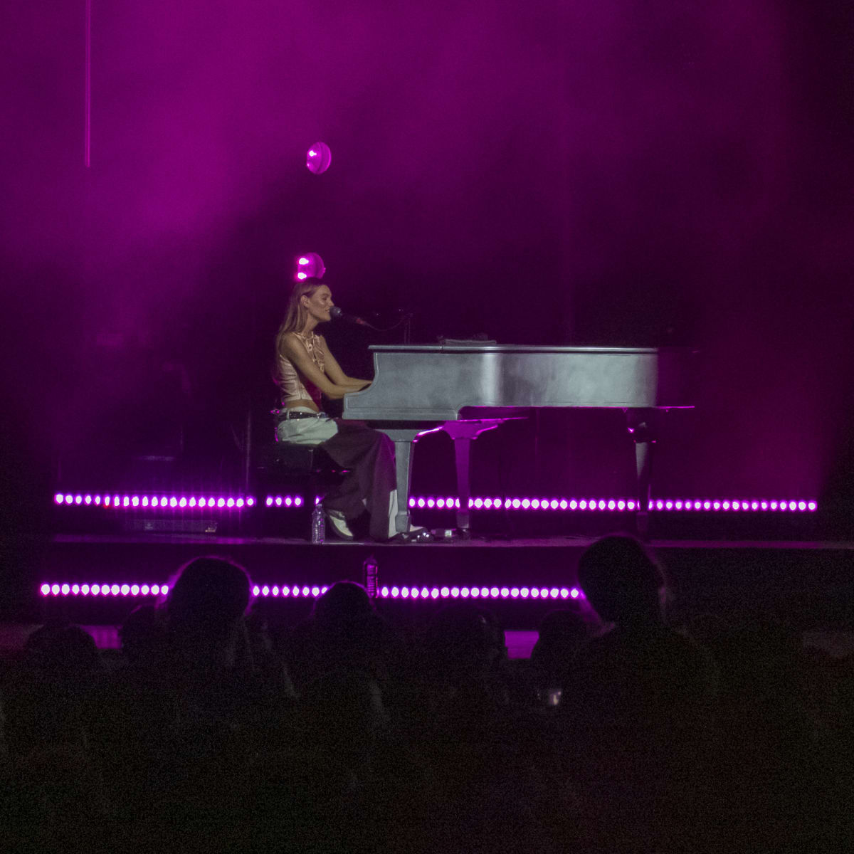 Charlotte Cardin au piano sur scène en soirée.
