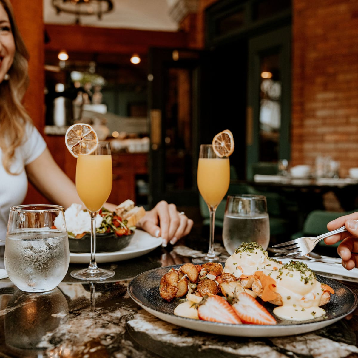 Couple sitting at a table enjoying breakfast.