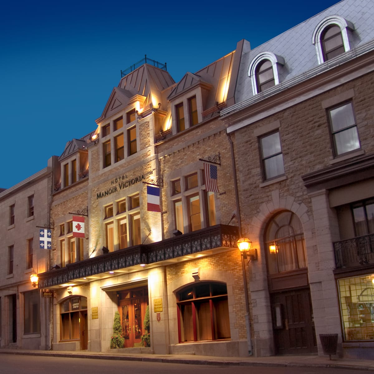 Front view of Hotel Manoir Victoria in early evening.
