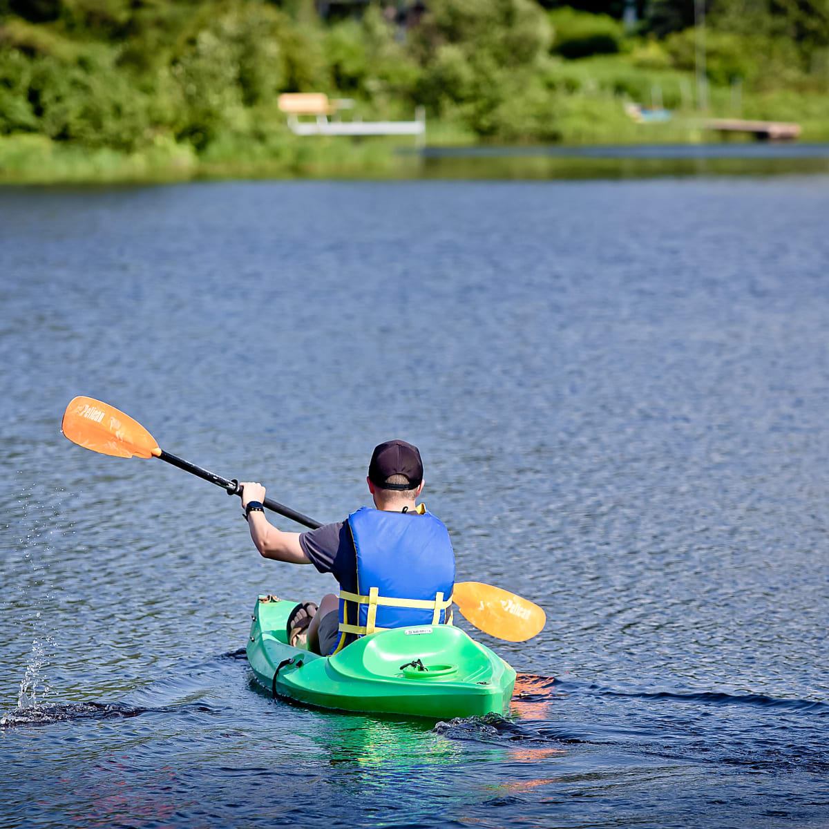 Homme de dos à la caméra en kayak sur le lac privé.