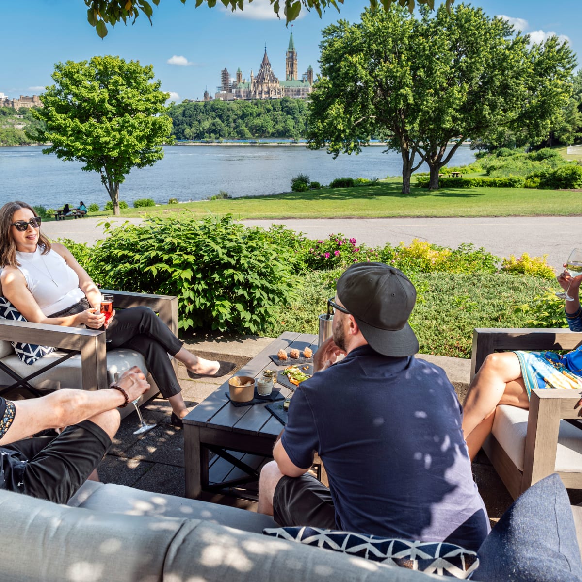 4 friends on patio furniture in front of the Ottawa River.