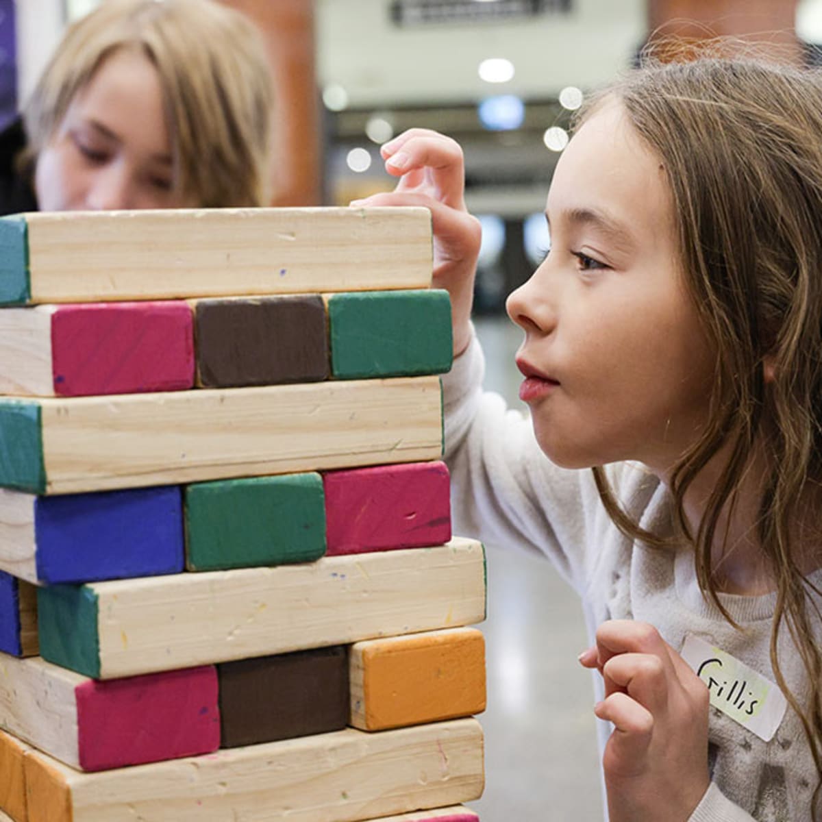 Two kids playing a Jenga game at the musem.