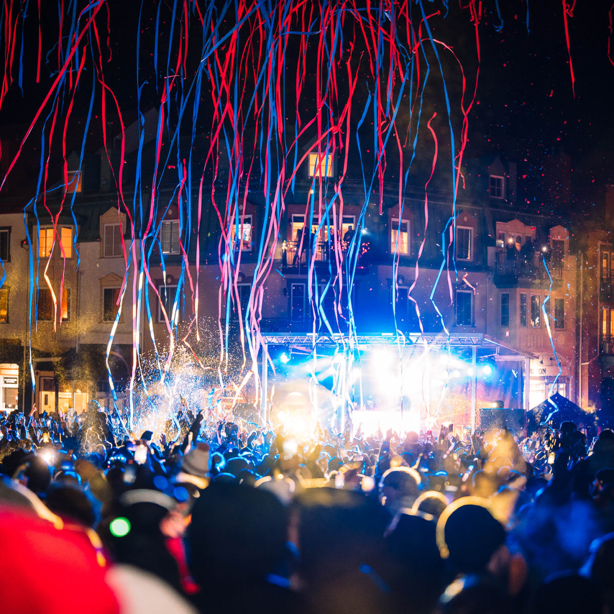 Confetti falling on a crowd gathered outdoors.