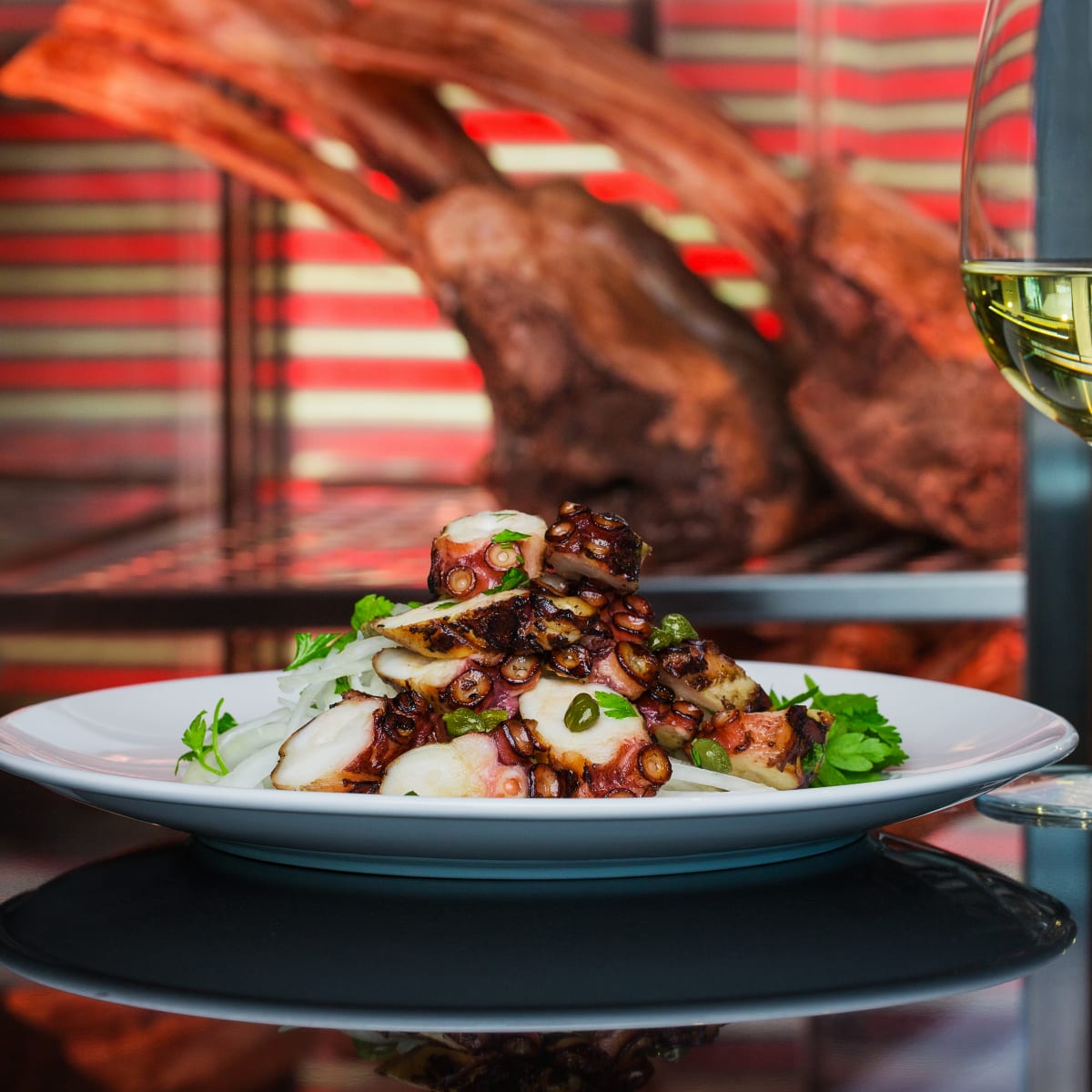 A plate of carefully prepared seafood, served with a glass of white wine.