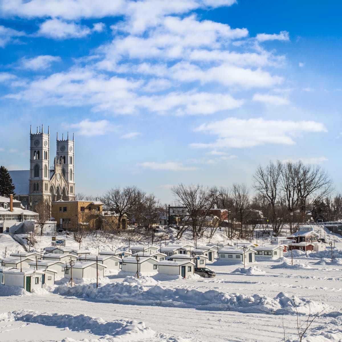 Village de pêche sur glace à Sainte-Anne-de-la-Pérade et église en arrière-plan.