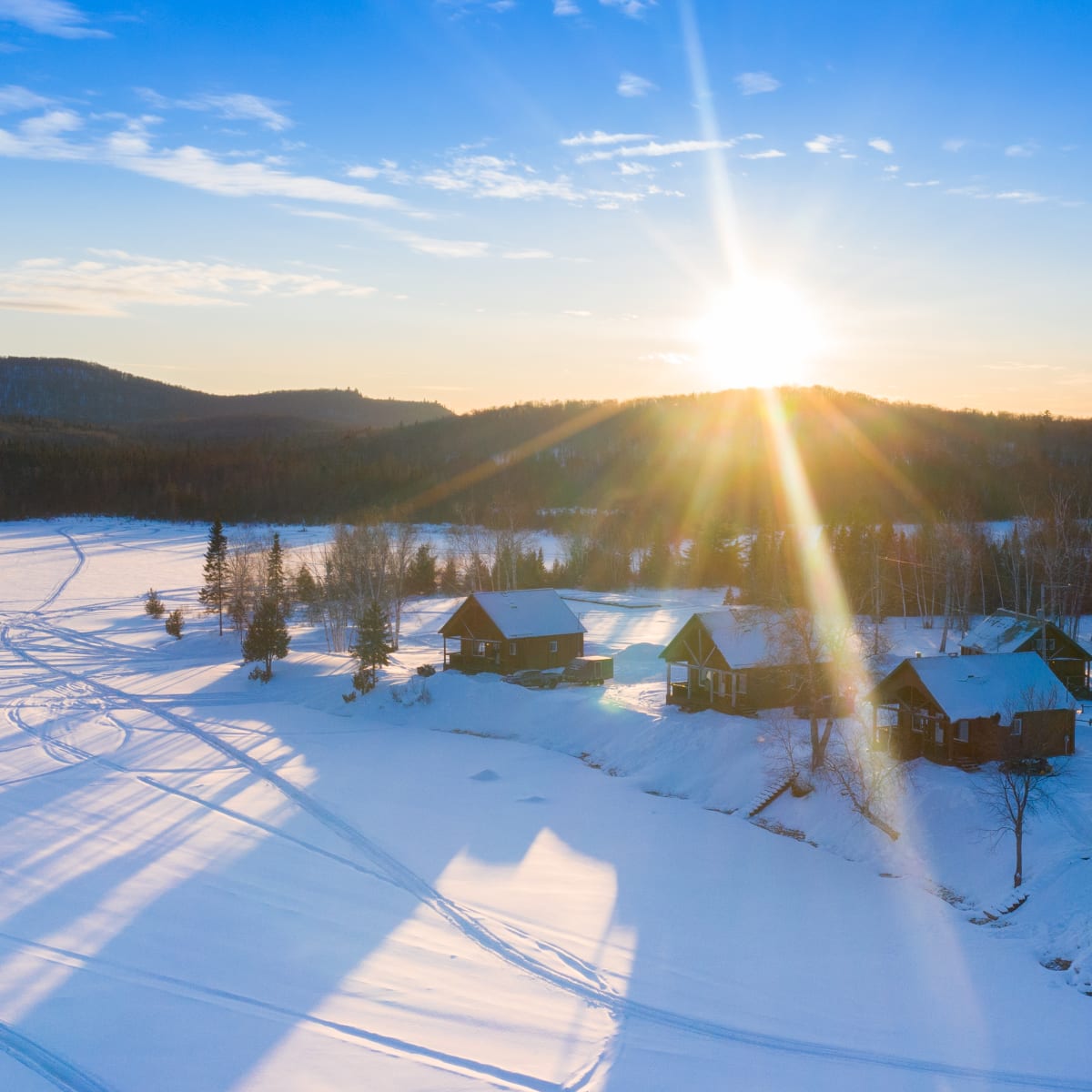 Aerial view of snow-covered lakeside cottages.