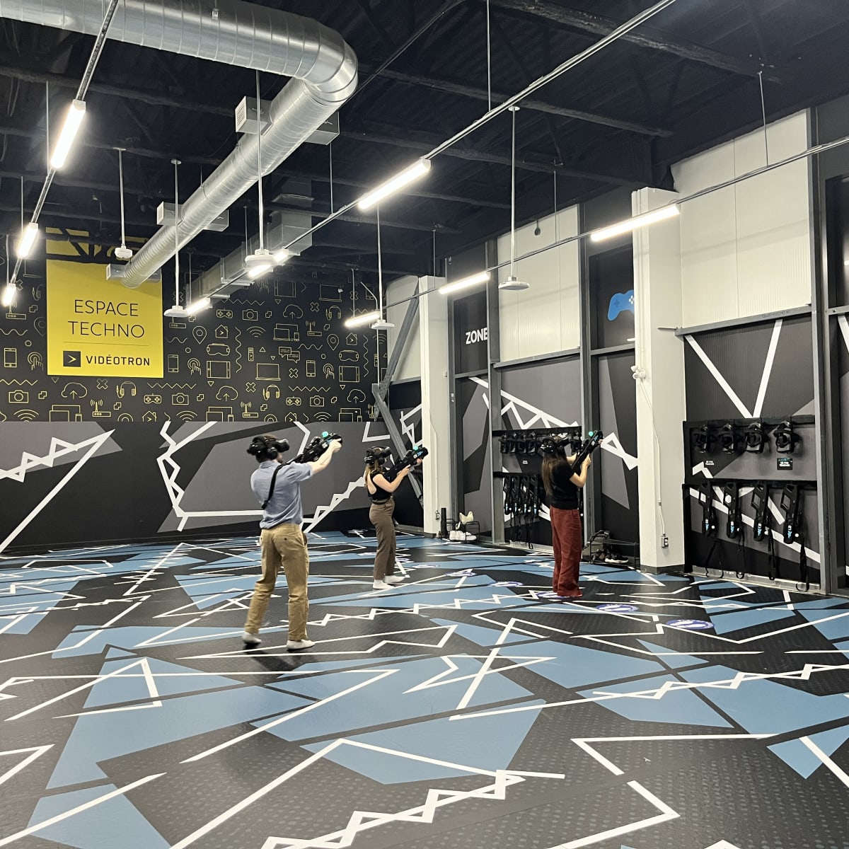 Trois personnes dans une arène de réalité virtuelle.