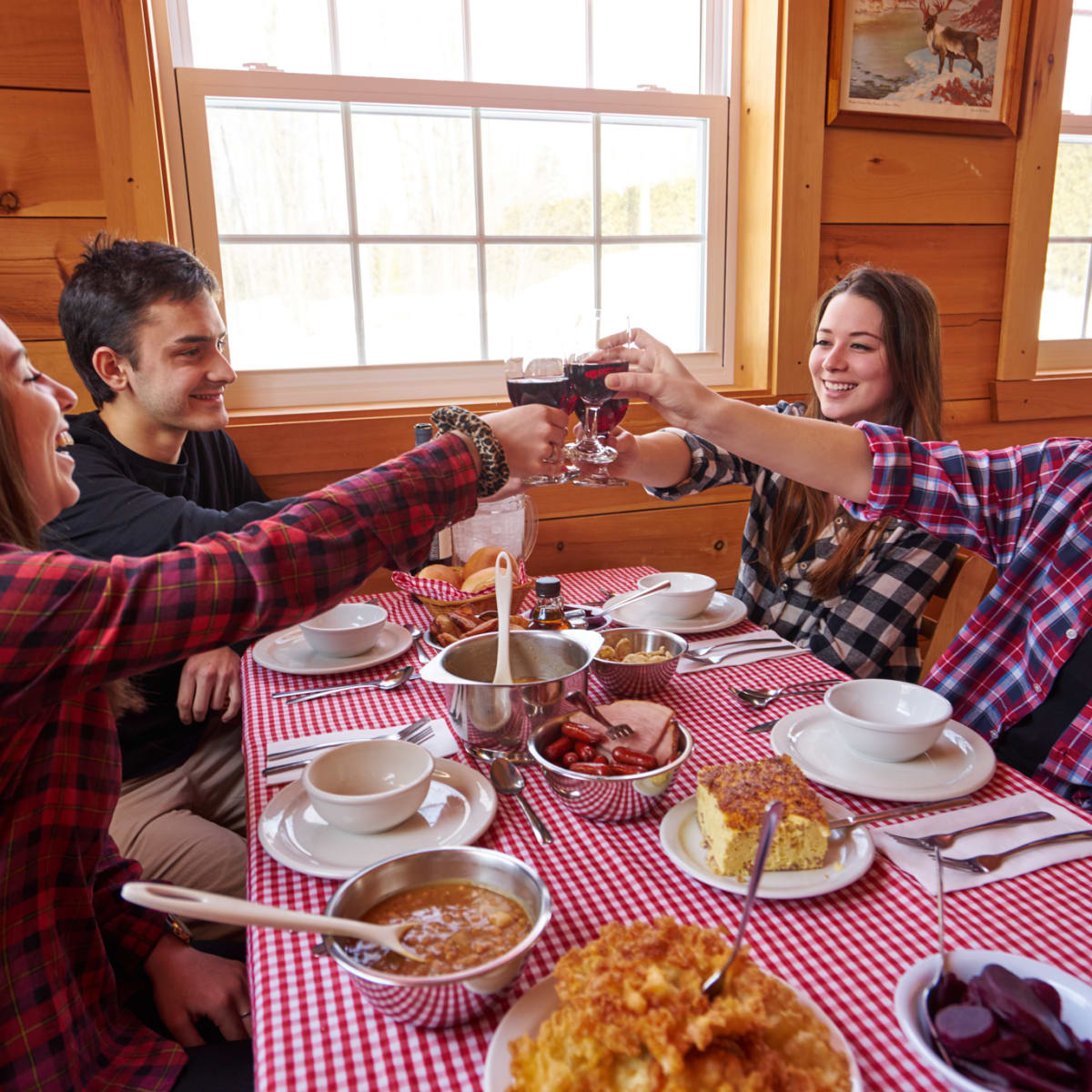 Group of four people raising their wine glass at the sugar shack.
