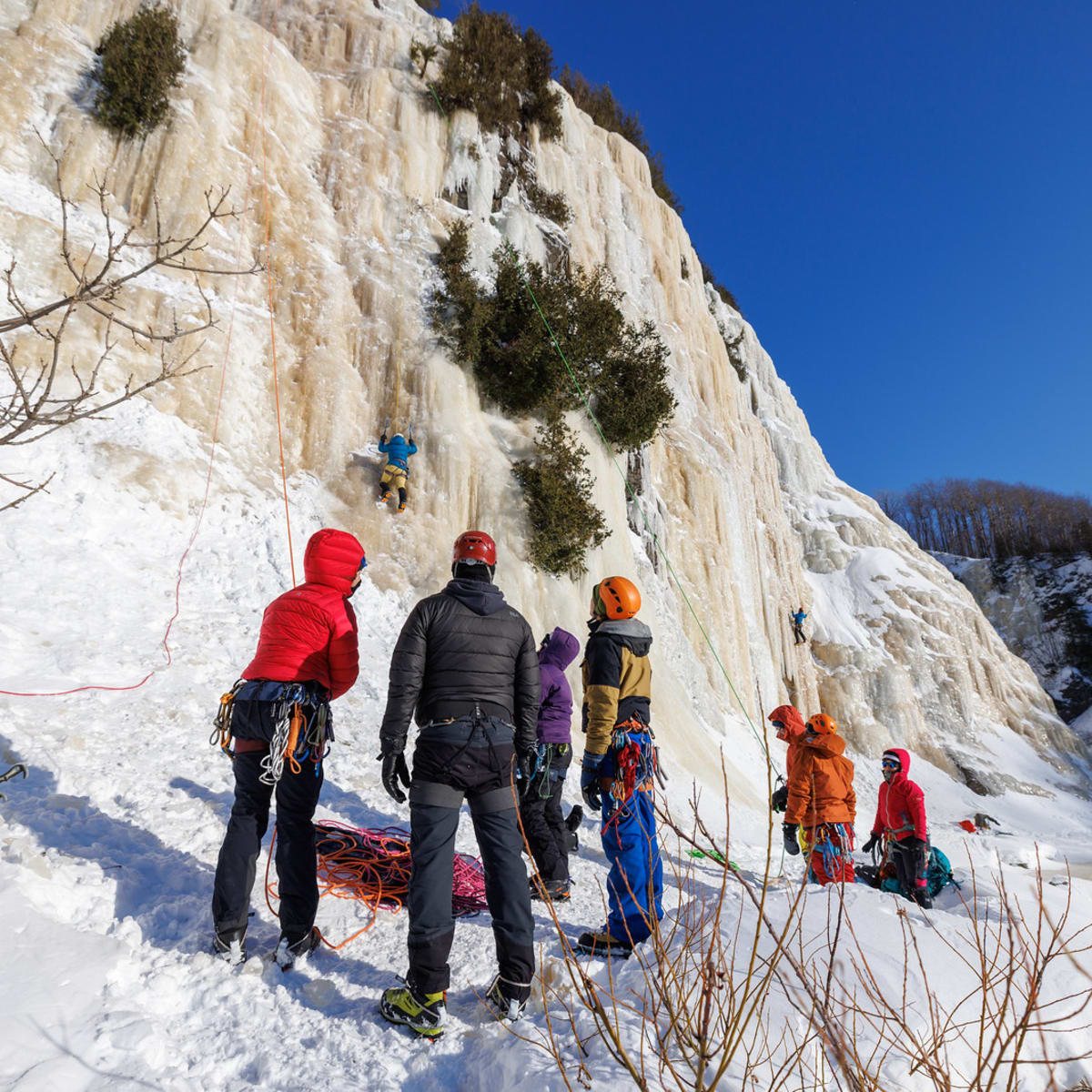 Groupe de personnes au pied d’une paroi glacée