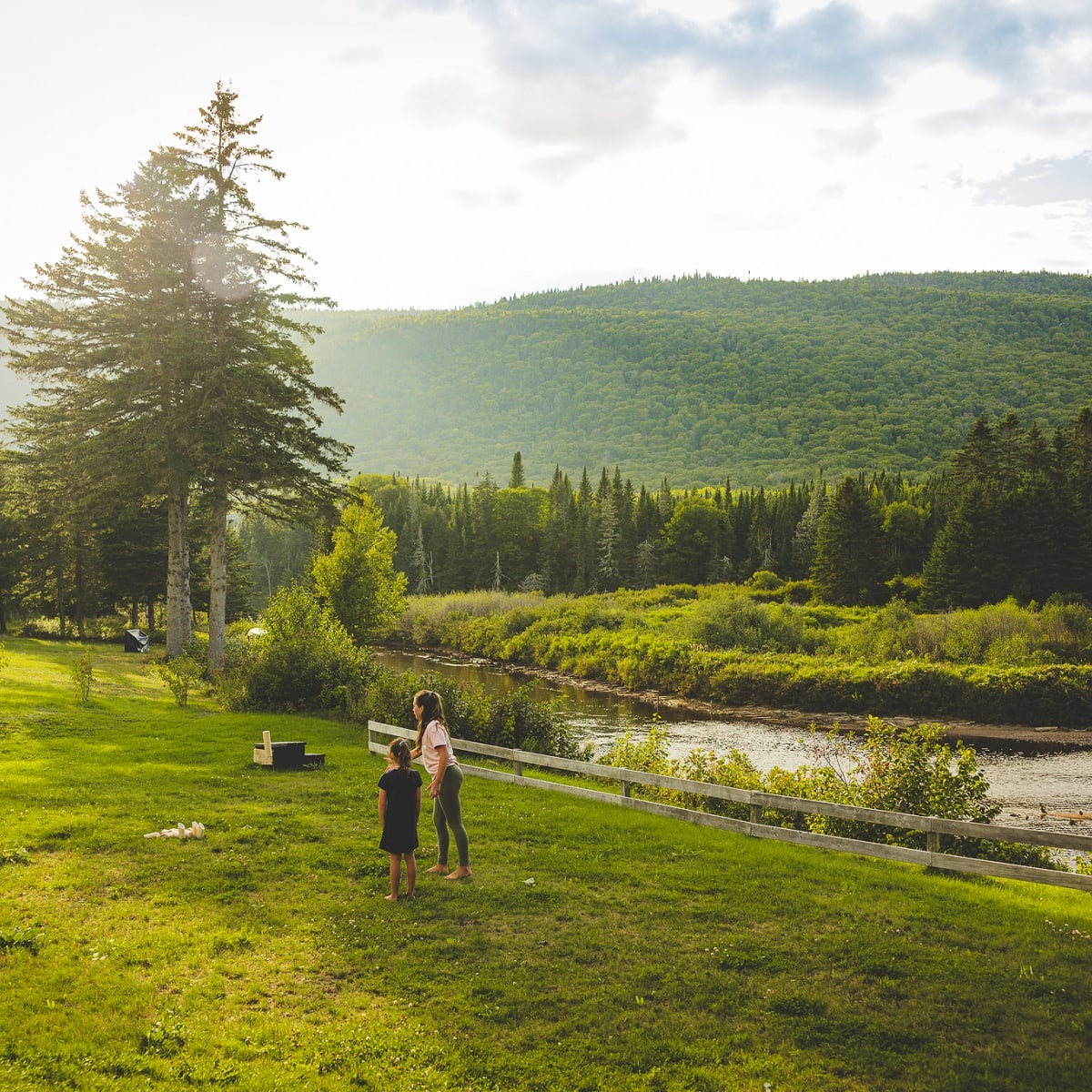 A mother and daughter in a wide-open natural landscape.