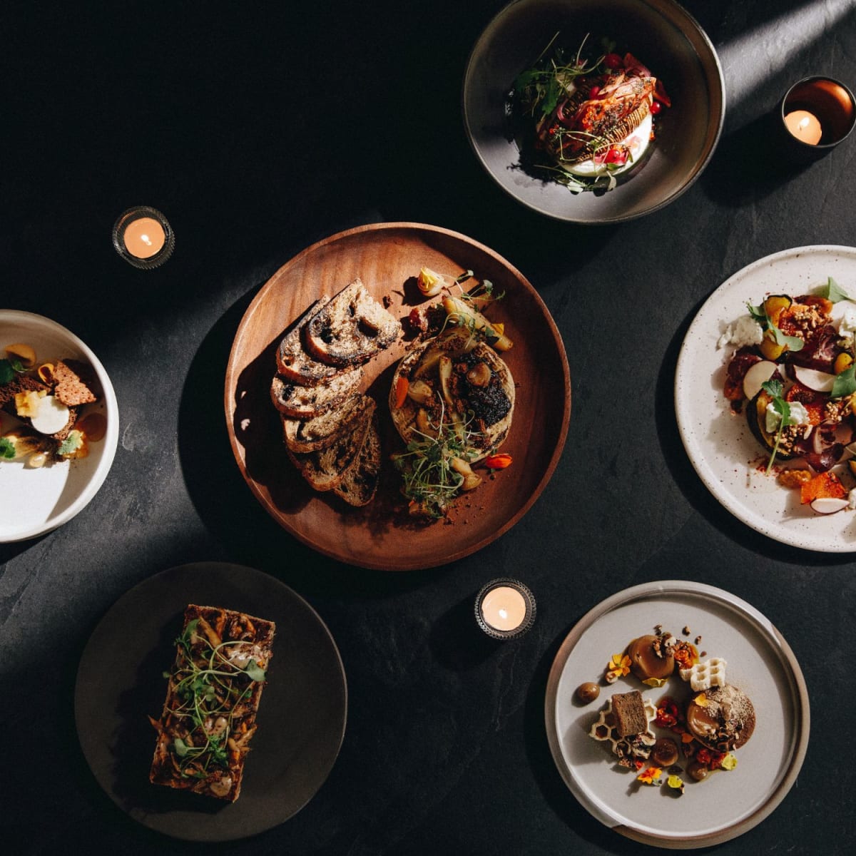 Variété de plats gastronomiques sur fond noir.