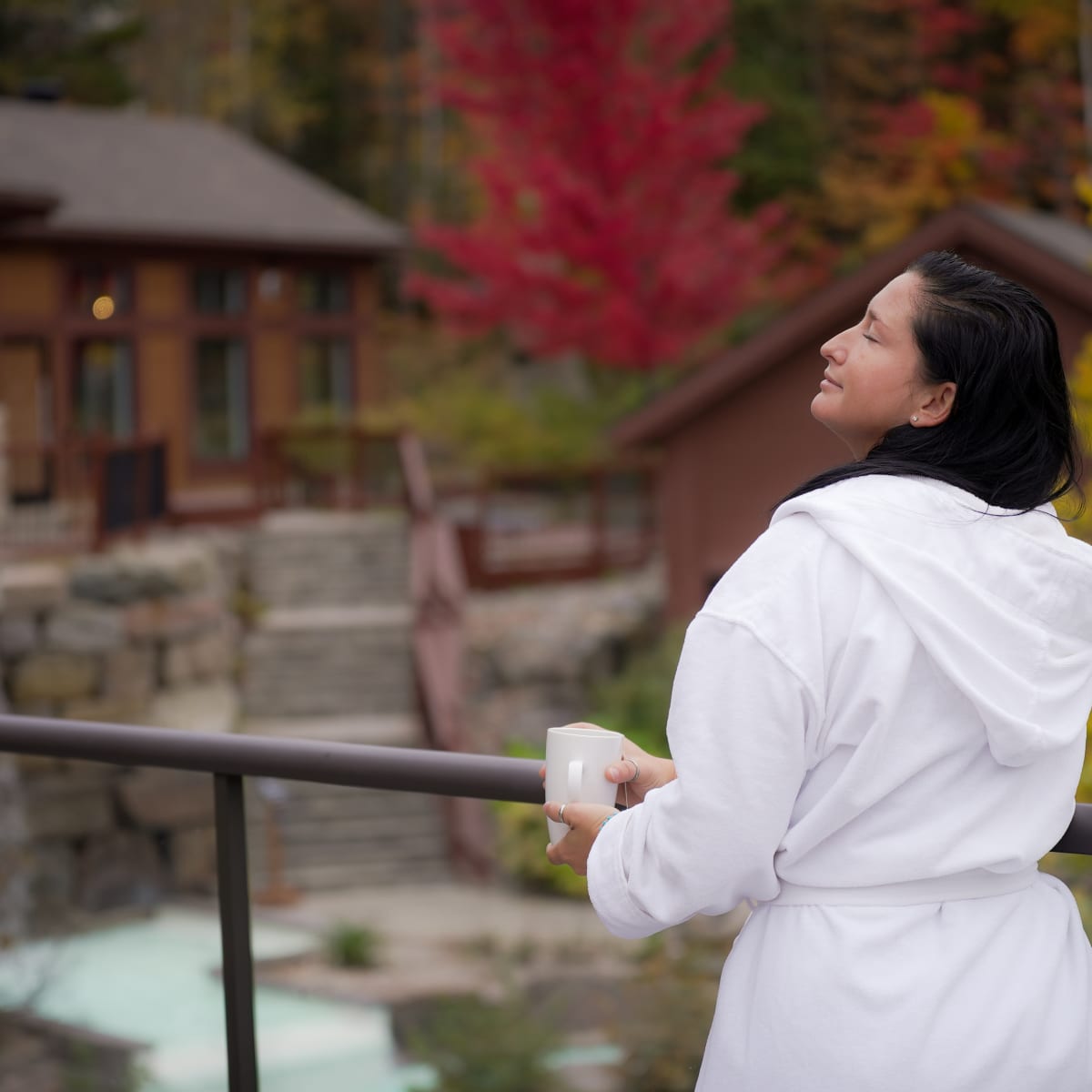 Femme en robe de spa sur le bord des installations thermales.