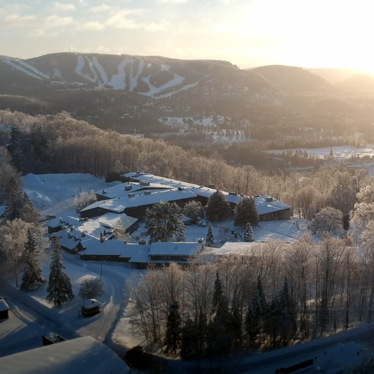 Vue aérienne de l’Hôtel Mont-Gabriel et d’un domaine skiable en arrière-plan.