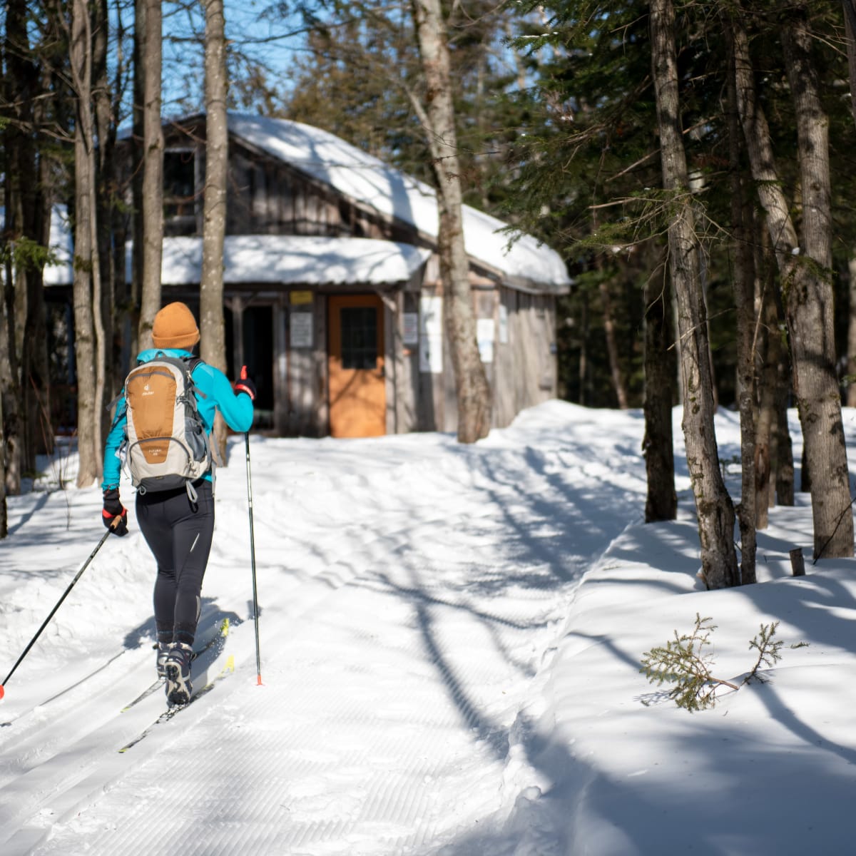 Fondeuse qui parcourt un sentier de ski de fond enneigé