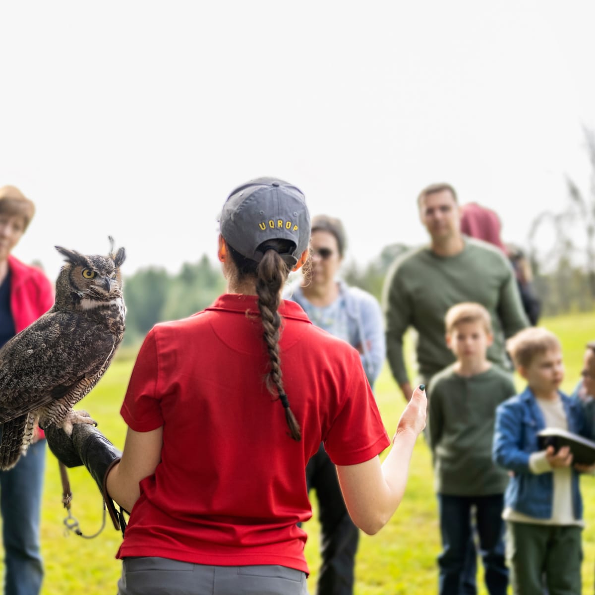 Guide giving a presentation with an owl in front of a few people.