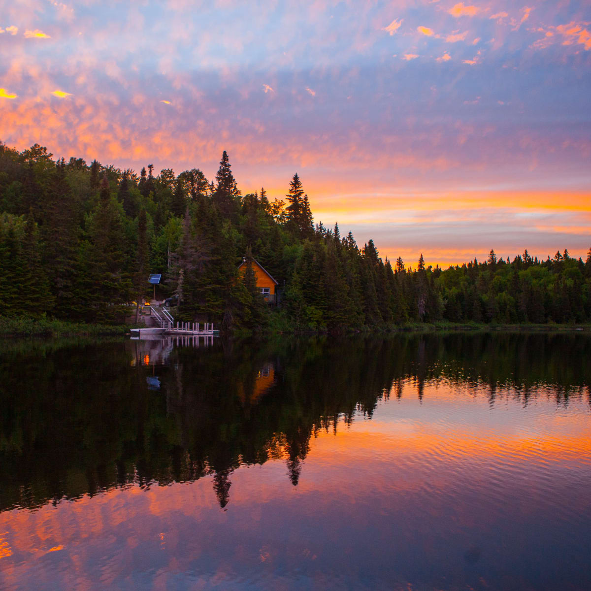 Cottage by a lake at sunset