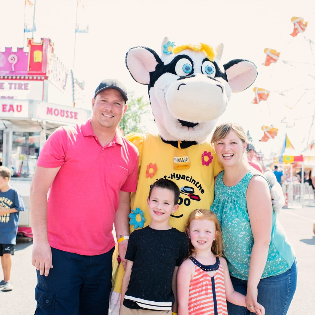 Famille de deux parents et deux enfants avec la mascotte de l'Expo agricole de Saint-Hyacinthe.