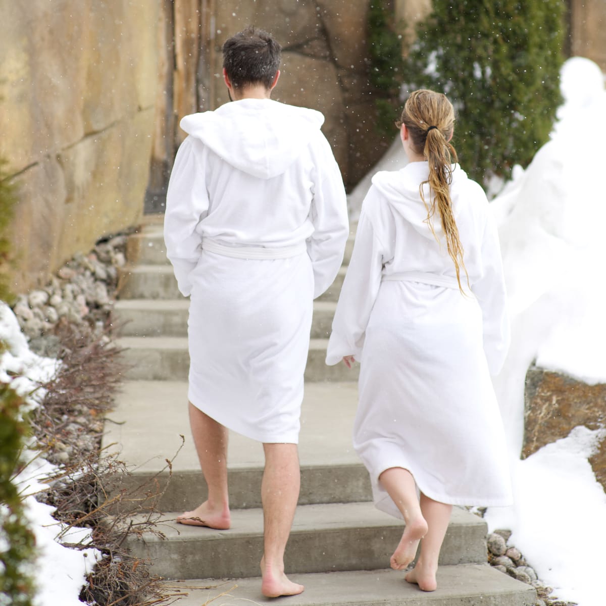 Couple marchant en peignoir dans un spa.