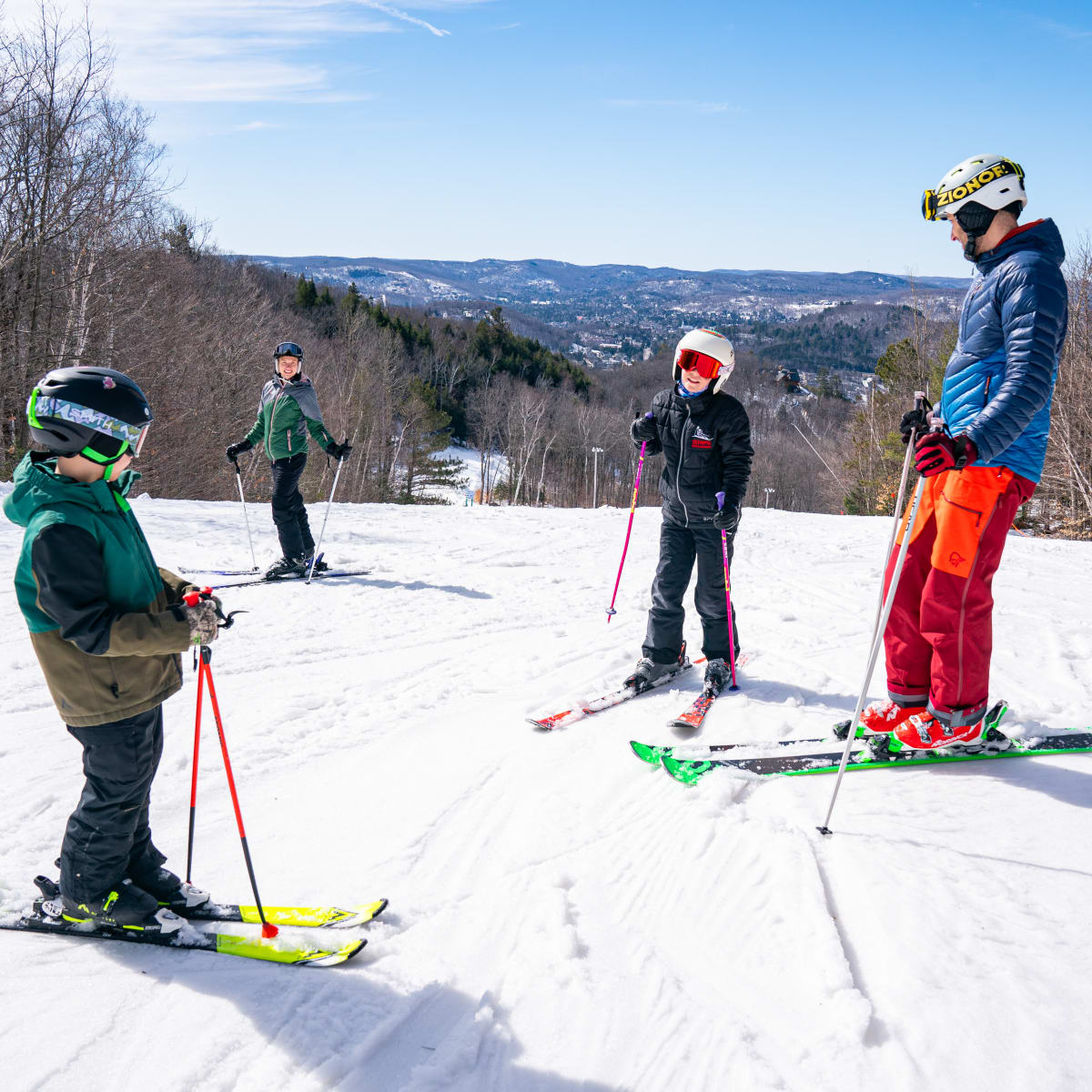 Deux adultes et deux enfants en ski au Sommet Olympia.